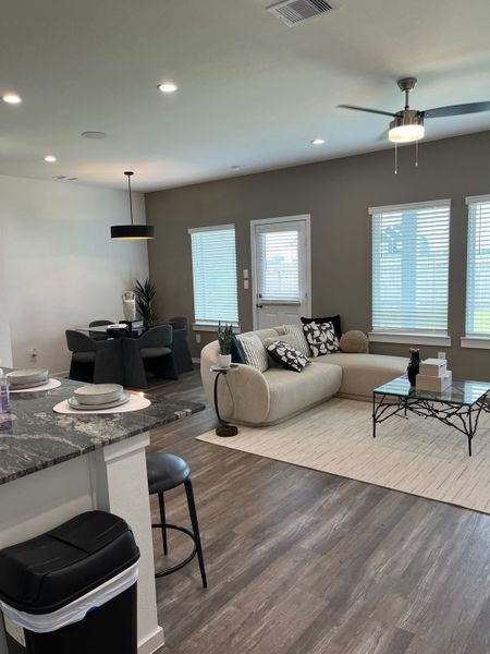 A modern living space with a cozy sofa, stylish dining area, and sleek lighting fixtures.