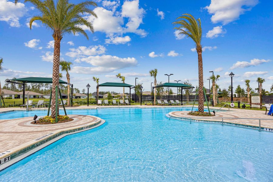 Community pool with palm trees, shade cabanas, and lounge seating in a residential neighborhood
