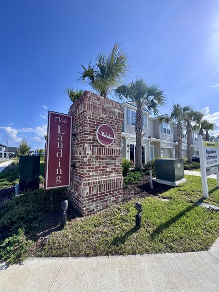 Charming townhomes with palm trees and a brick entrance at The Landing by D.R. Horton in Middleburg, FL.