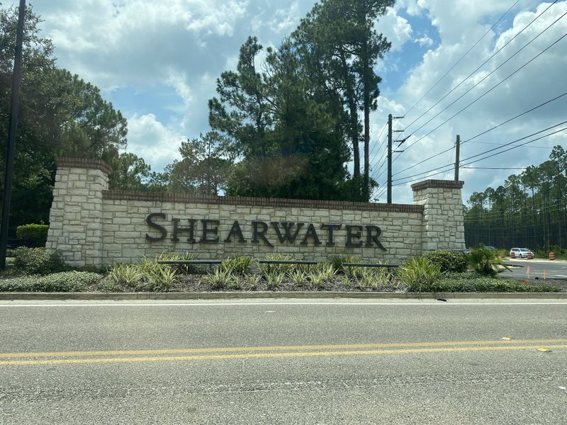 Beautifully crafted stone entry for Shearwater Townhomes by Ryan Homes in St. Augustine, FL, surrounded by lush greenery. Beautifully crafted stone entry for Shearwater Townhomes by Ryan Homes in St. Augustine, FL, surrounded by lush greenery.