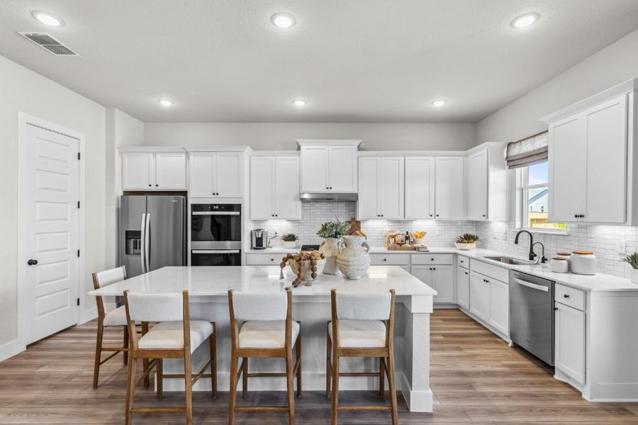 A kitchen with white cabinets.