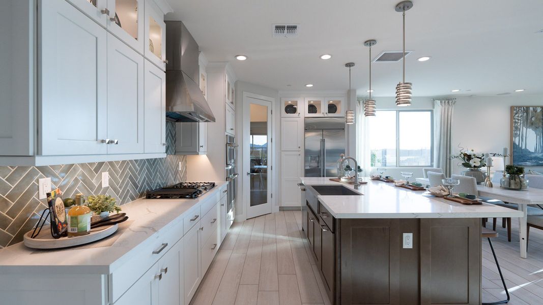 Step into elegance with this kitchen's sleek island, premium finishes, and custom cabinetry in The Villas at Mystic.