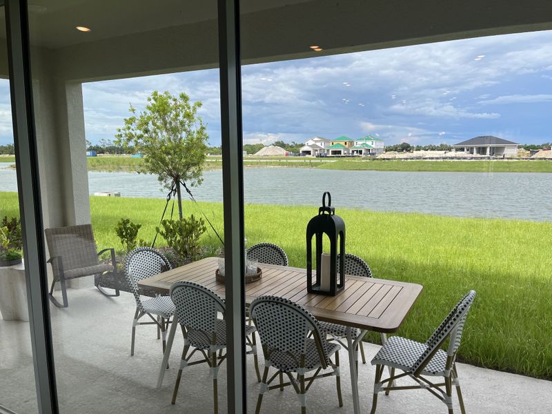 A serene patio with a stylish dining set overlooks a picturesque lake, with lush greenery and vibrant surroundings. A serene patio with a stylish dining set overlooks a picturesque lake, with lush greenery and vibrant surroundings.