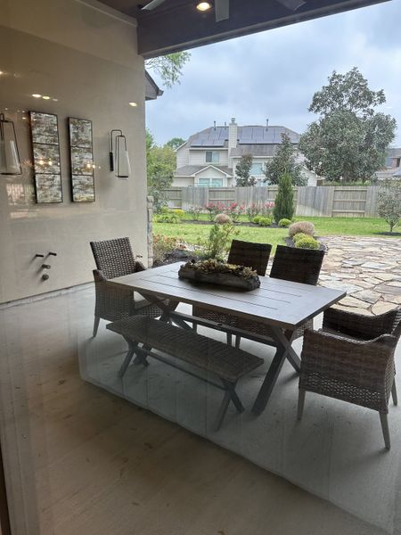 A cozy patio with wicker furniture and a garden view, offering a serene outdoor retreat.
