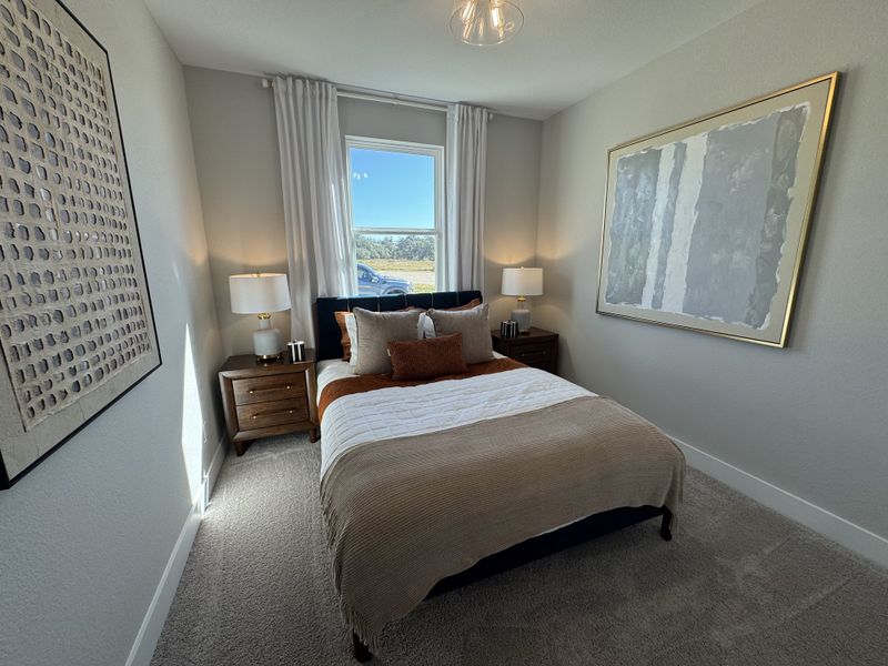 A cozy bedroom with elegant large artwork, stylish lamps, and a plush bed. Neutral tones create a serene atmosphere.