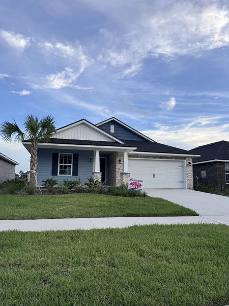 A charming blue home with a lush yard in Rolling Hills by LGI Homes (Green Cove Springs, FL).
