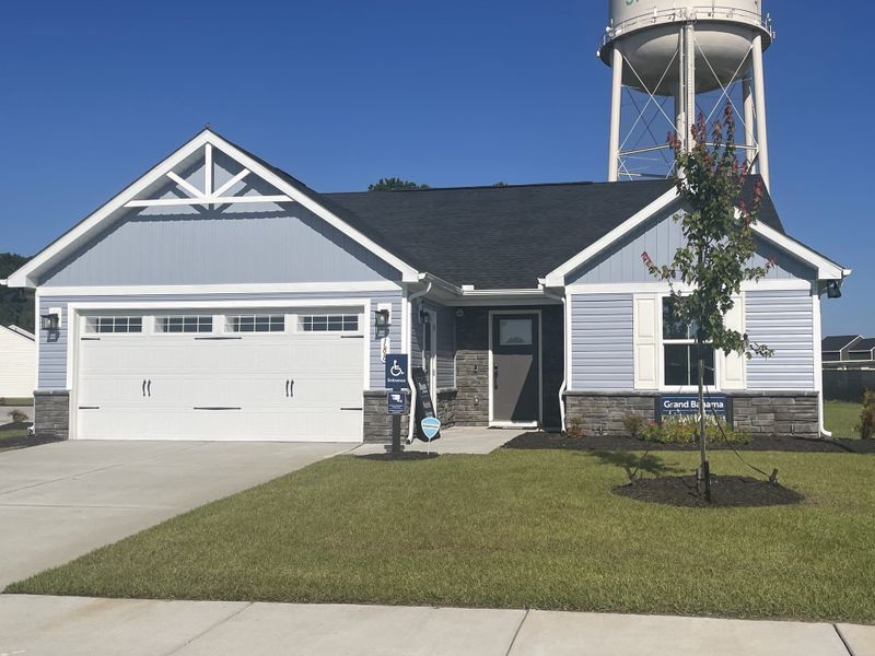 A charming blue and gray ranch-style home with a spacious garage in Somerset Two-Story Homes by Ryan Homes (Santee, SC).
