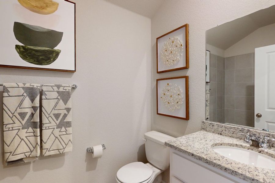 A bathroom with a sink toilet and a mirror. A bathroom with a sink toilet and a mirror.