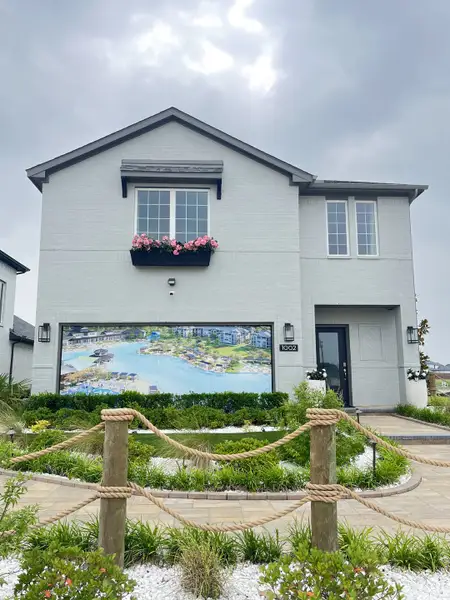 A modern white brick home with landscaped front in Bellagio by Megatel Homes (Forney, TX).