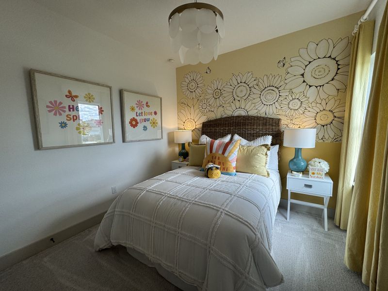 A cozy bedroom with a floral accent wall, cheerful decor, and warm lighting creates a welcoming atmosphere.