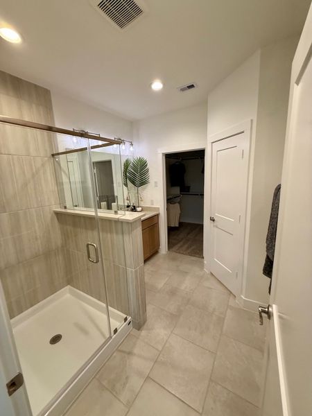A modern bathroom with a glass shower, beige tiling, and sleek vanity, creating a fresh and inviting ambiance. A modern bathroom with a glass shower, beige tiling, and sleek vanity, creating a fresh and inviting ambiance.