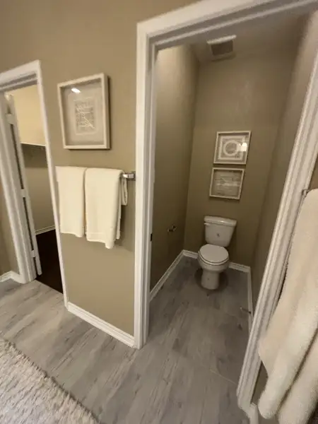 A cozy bathroom with beige walls, framed artwork, and elegant tile flooring. A cozy bathroom with beige walls, framed artwork, and elegant tile flooring.