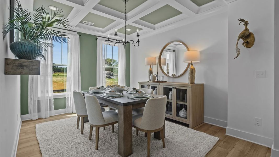 Cozy dining room with green accented coffered ceilings, modern chandelier, and large windows in Piedmont, SC