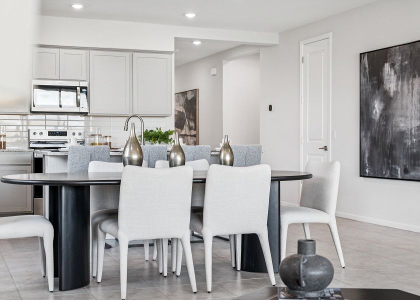 A kitchen with a table and chairs.