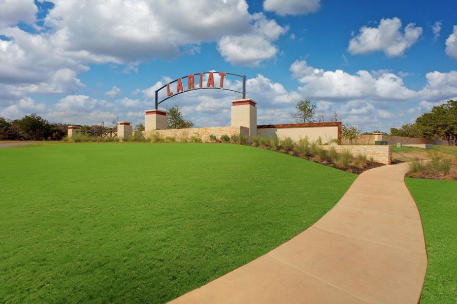 Entrance to the Lariat community in Liberty Hill, TX, featuring signage and landscaping (Image 4).