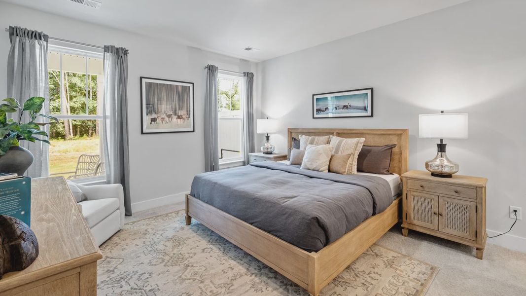 Primary bedroom with en suite bathroom, elevated ceilings, and hardwood flooring at Aspen Ridge by DRB Homes in Lyman, SC Primary bedroom with en suite bathroom, elevated ceilings, and hardwood flooring at Aspen Ridge by DRB Homes in Lyman, SC