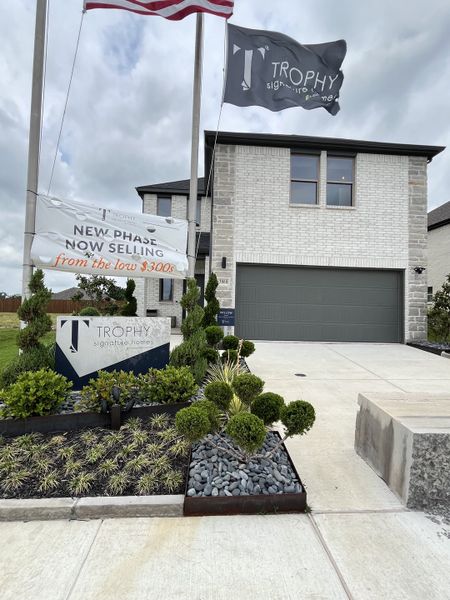 A modern white brick home with elegant landscaping in Southridge by Trophy Signature Homes (McKinney, TX).