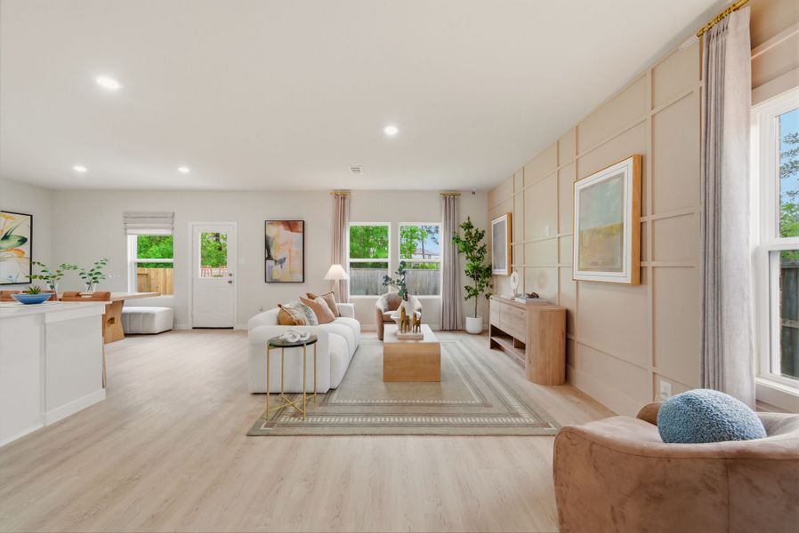 A large living room with a large rug and a large window.