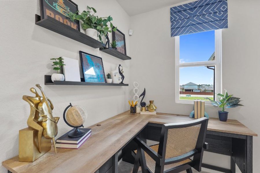 A desk with a chair and a statue on it.