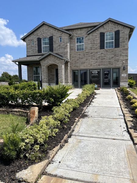 A charming brick home with lush landscaping in Heights of Barbers Hill by Meritage Homes (Baytown, TX).