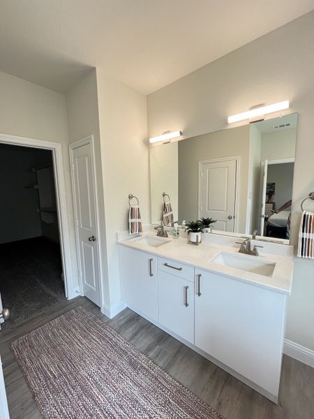 A modern bathroom featuring a double vanity with sleek fixtures, a large mirror, and elegant lighting for a refined touch.