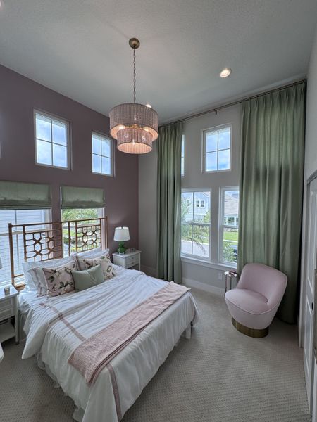 A serene bedroom with tall windows, soft lighting, and a pink accent chair, creating an inviting, cozy atmosphere. A serene bedroom with tall windows, soft lighting, and a pink accent chair, creating an inviting, cozy atmosphere.