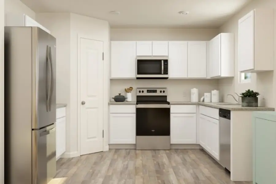 A kitchen with white cabinets.
