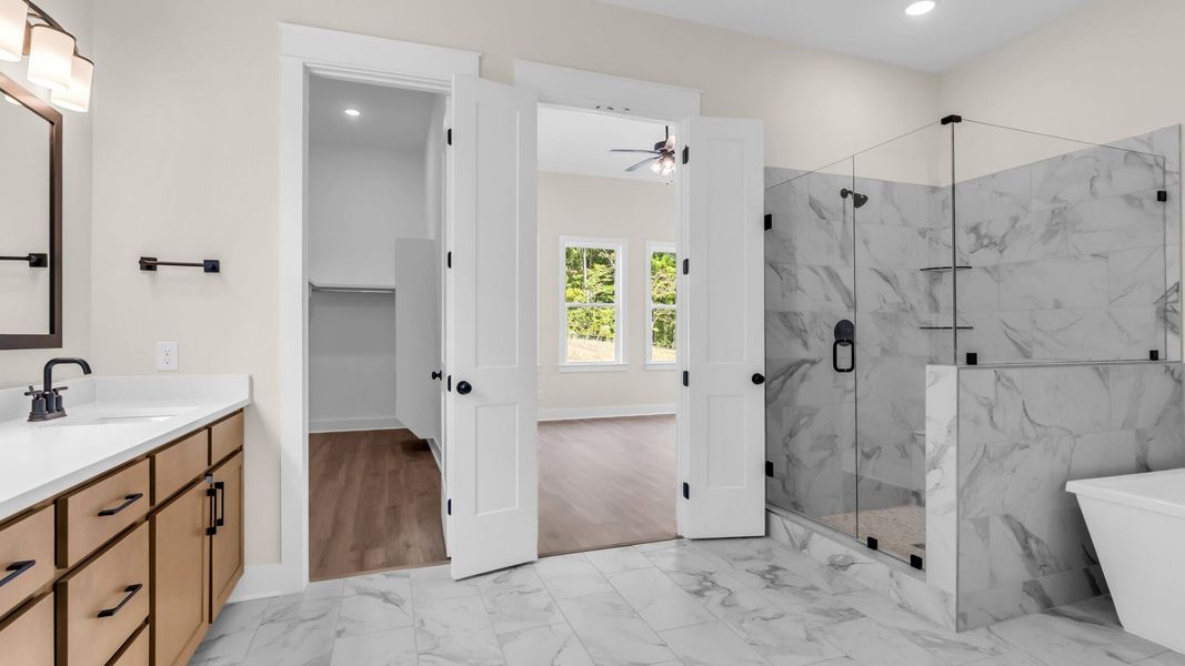Primary suite bathroom with gorgeous tile, frameless shower, freestanding tub, and walk in closet` Primary suite bathroom with gorgeous tile, frameless shower, freestanding tub, and walk in closet`