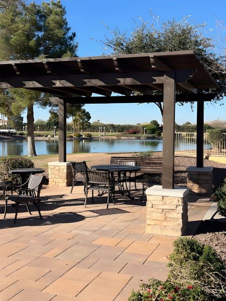 A charming lakeside patio with pergola and seating in The Preserve at Province II by Meritage Homes (Maricopa, AZ).