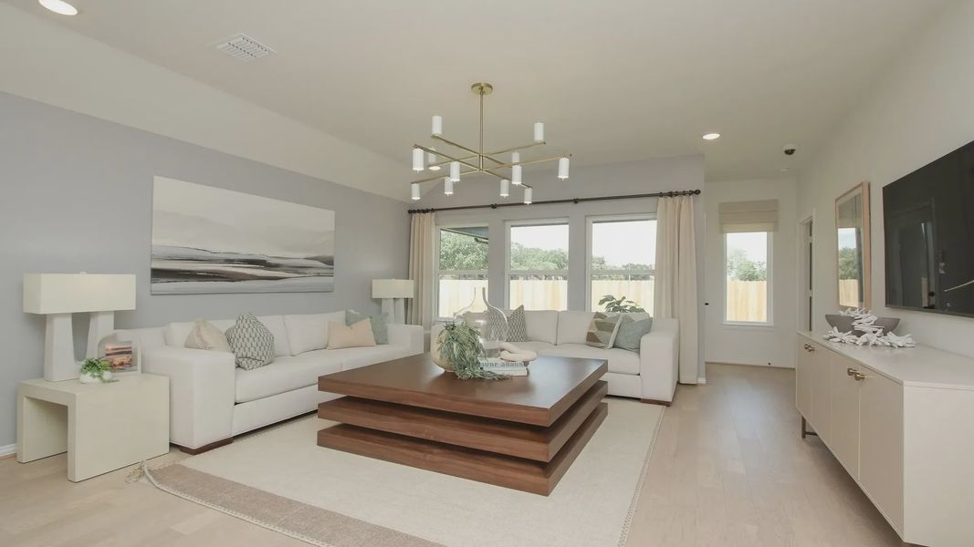 Elegant living room with sleek furnishings, modern chandelier, and expansive windows in Ellis Cove. Elegant living room with sleek furnishings, modern chandelier, and expansive windows in Ellis Cove.