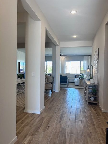 An airy, open-concept living area with light wood flooring, neutral walls, and large windows for natural light. An airy, open-concept living area with light wood flooring, neutral walls, and large windows for natural light.