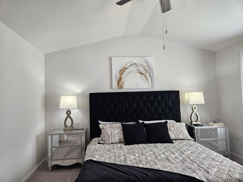 A cozy bedroom with a tufted headboard, elegant bedside tables, and abstract artwork.