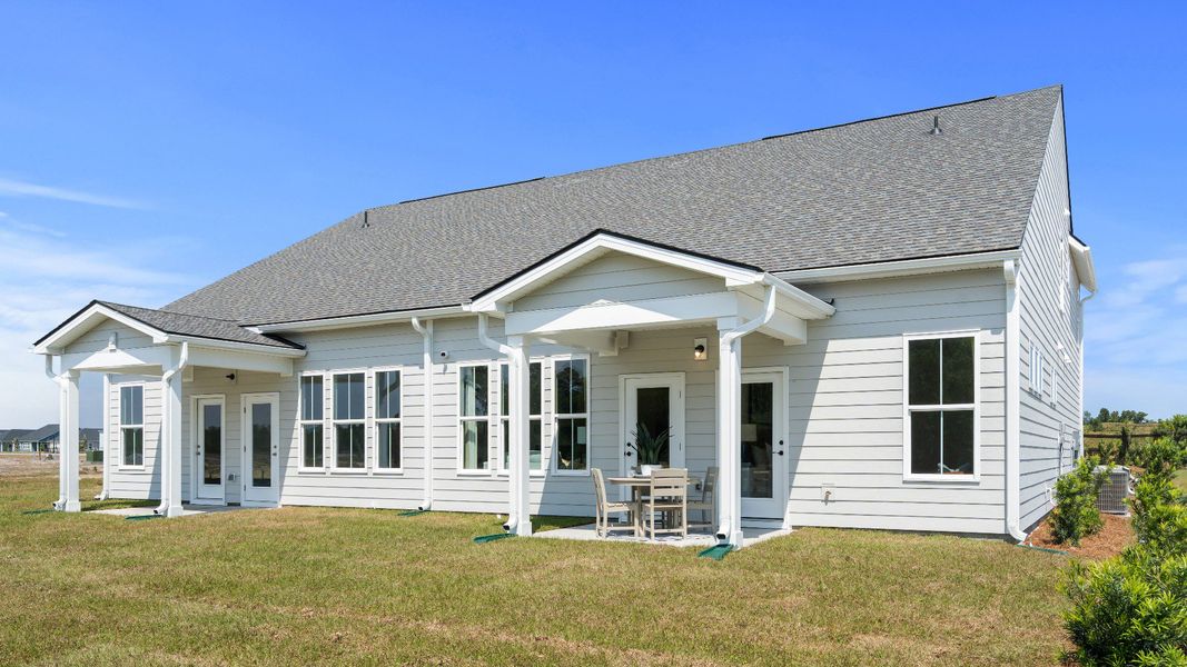 Rear exterior of the Summit home plan showcasing covered outdoor living and villa design.