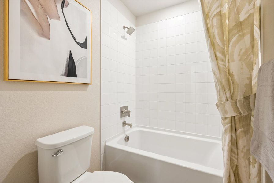 A bathroom with a tub toilet and a mirror. A bathroom with a tub toilet and a mirror.