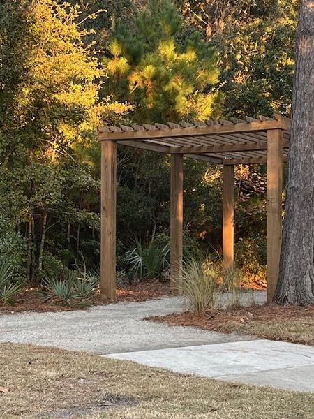 A peaceful outdoor pergola surrounded by nature in Liberty Hill Farm by K. Hovnanian® Homes (Mount Pleasant, SC).