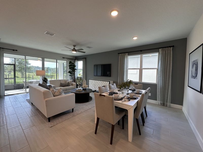 An elegant open-plan living and dining area with large windows, modern furnishings, and serene outdoor views.