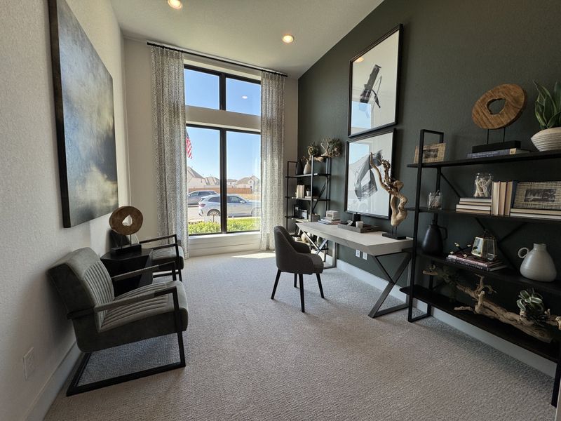 A modern study with elegant decor, featuring large windows, stylish shelving, and plush seating.