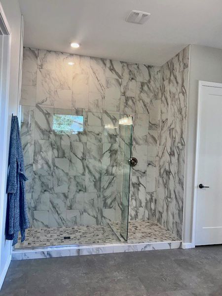 A luxurious shower with elegant marble tiles and modern fixtures. A luxurious shower with elegant marble tiles and modern fixtures.
