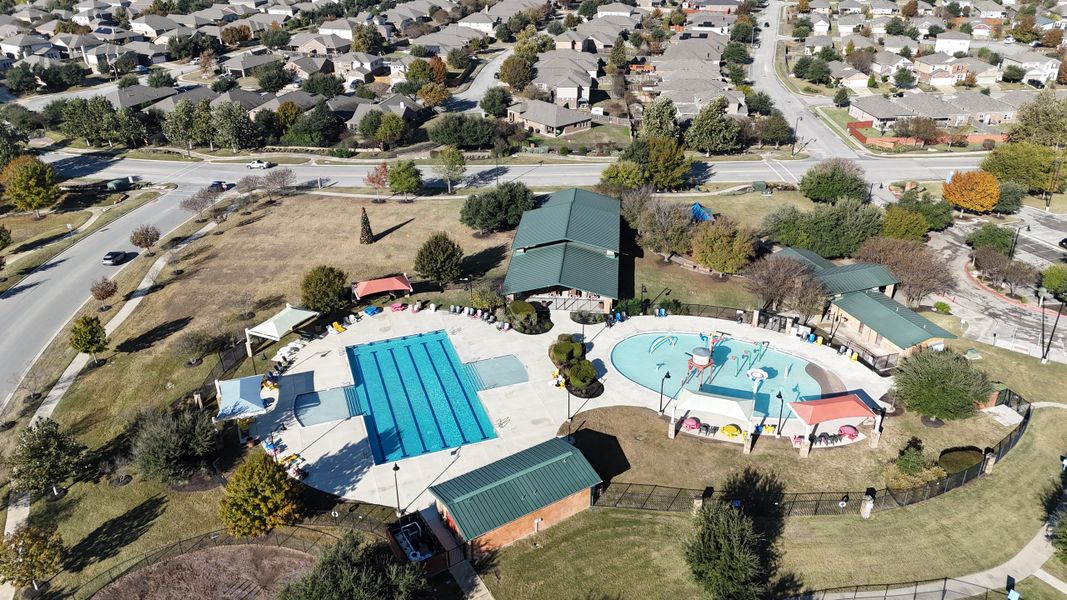 An aerial view of Sunfield's recreational area with pools and green spaces by CastleRock Communities in Buda, TX.