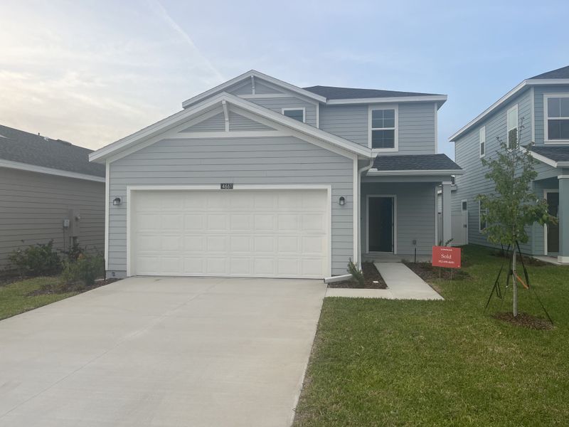 A charming gray home with a spacious driveway and fresh landscaping in Marion Ranch by Lennar (Ocala, FL).