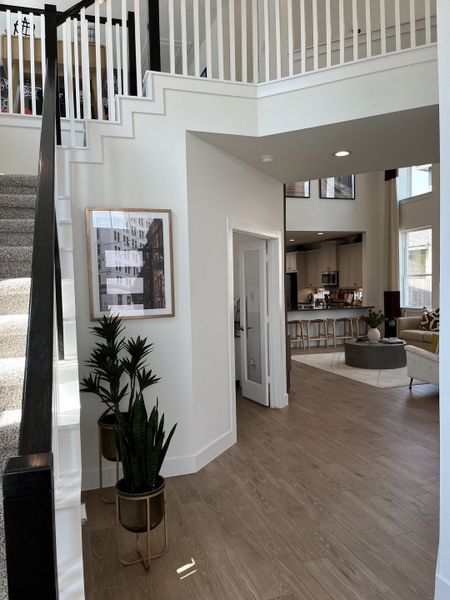 A contemporary interior featuring an elegant staircase, open floor plan, and stylish decor with natural wood flooring.