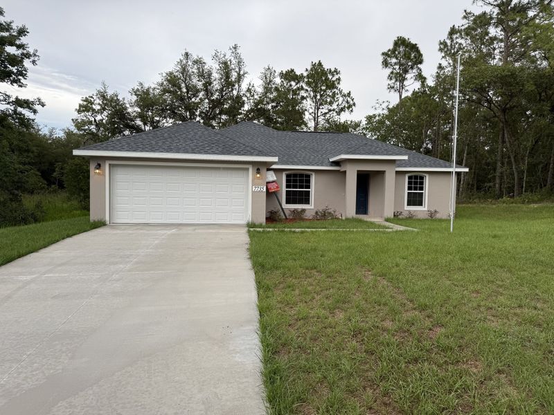 A charming beige home with a spacious driveway in Marion Oaks by Perfect Deed Homes in Ocala, FL.