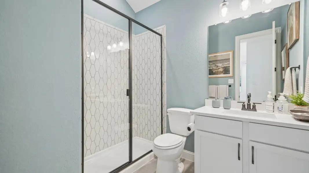 Secondary bathroom with ceramic tile shower, black framed glass door, and single vanity Secondary bathroom with ceramic tile shower, black framed glass door, and single vanity