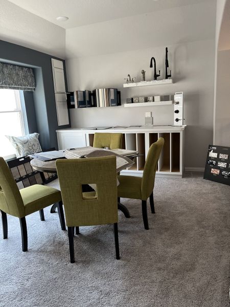 A cozy design room with lime green chairs, plush carpet, and samples of fixtures and materials on display. A cozy design room with lime green chairs, plush carpet, and samples of fixtures and materials on display.