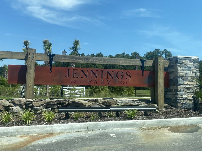 A welcoming entrance to Jennings Farm by Dream Finders Homes in Middleburg, FL, marked by rustic stone and wood accents.