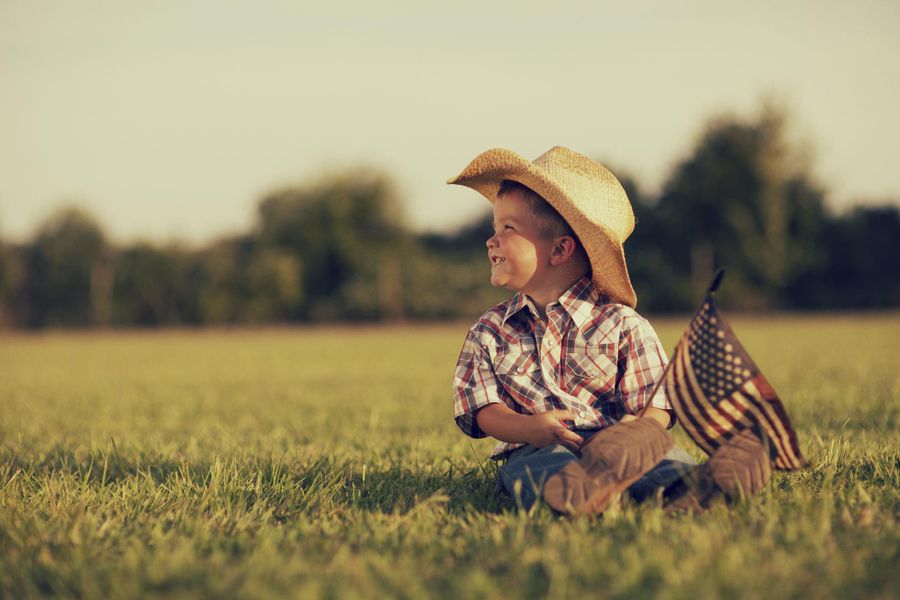 Child Sitting in Grassy Field