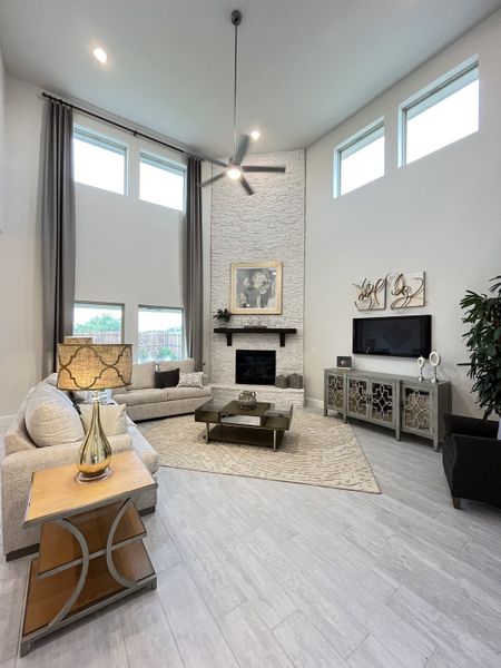 A spacious living room with high ceilings, cozy sectional, modern fireplace, and elegant decor.