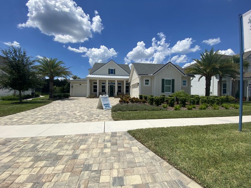 Charming white home with lush landscaping and palm trees in Courtney Oaks at SilverLeaf by Riverside Homes (St. Augustine, FL).