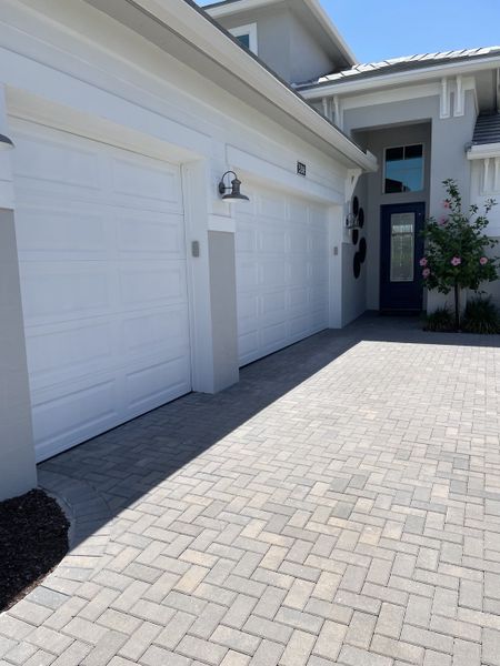 A sleek modern home with a bright garage and manicured driveway in Cresswind Palm Beach at Westlake by Kolter Homes (Westlake, FL).