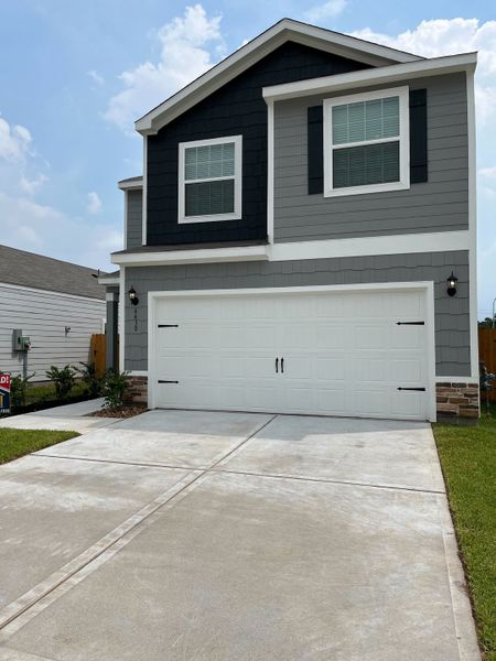 A modern two-story home with a sleek design and spacious driveway in Park Vista at El Tesoro by LGI Homes (Houston, TX).